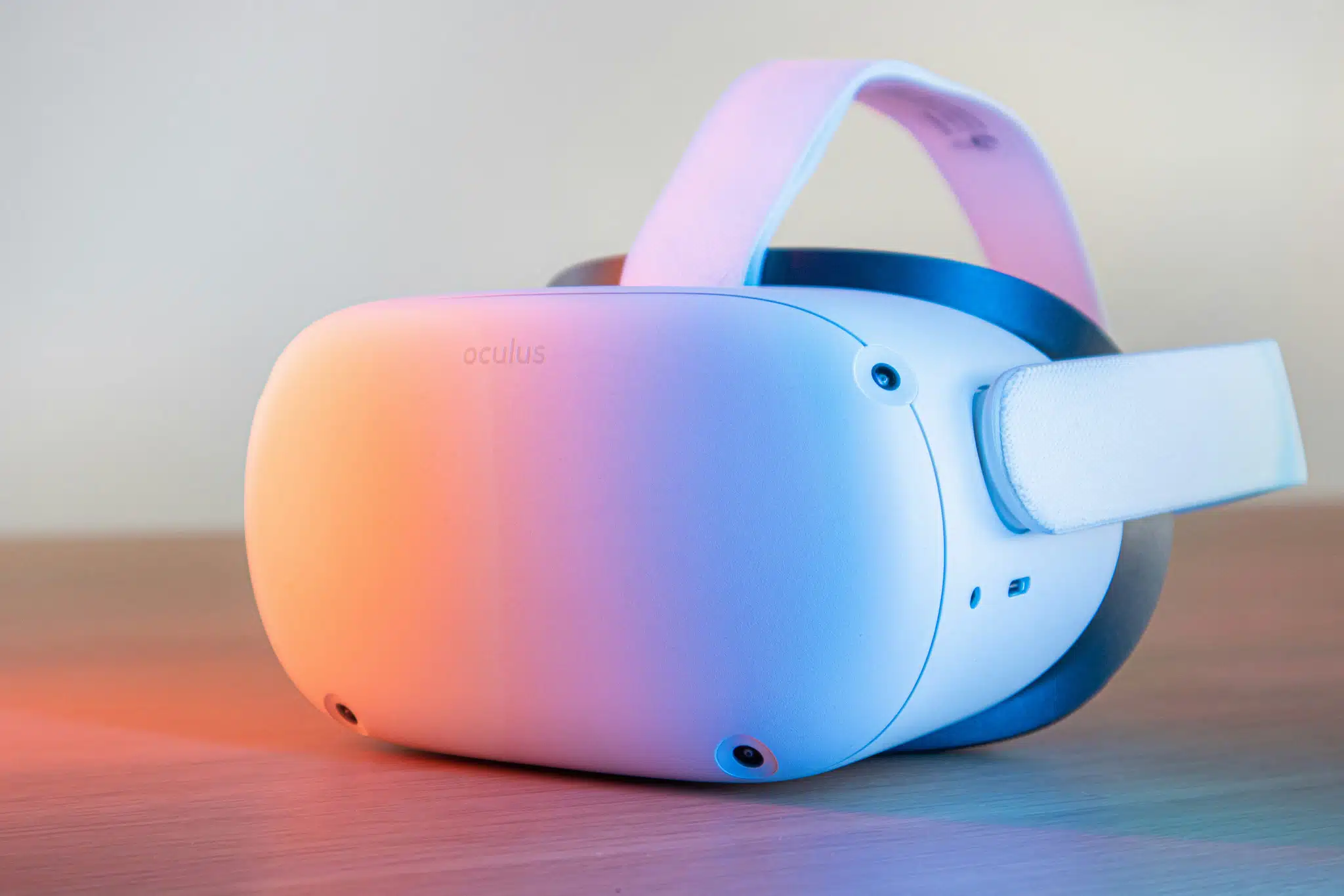 Meta Quest 2 (Oculus) VR-prillid lauaplaadil – valge standalone headset roosa ja sinise neonvalgusega, küljelt lähivõte